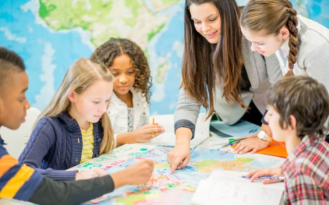 This is a photo of some young students and their teacher examining a large map.