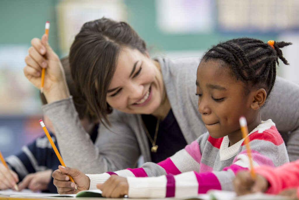 teacher working with student on writing skills