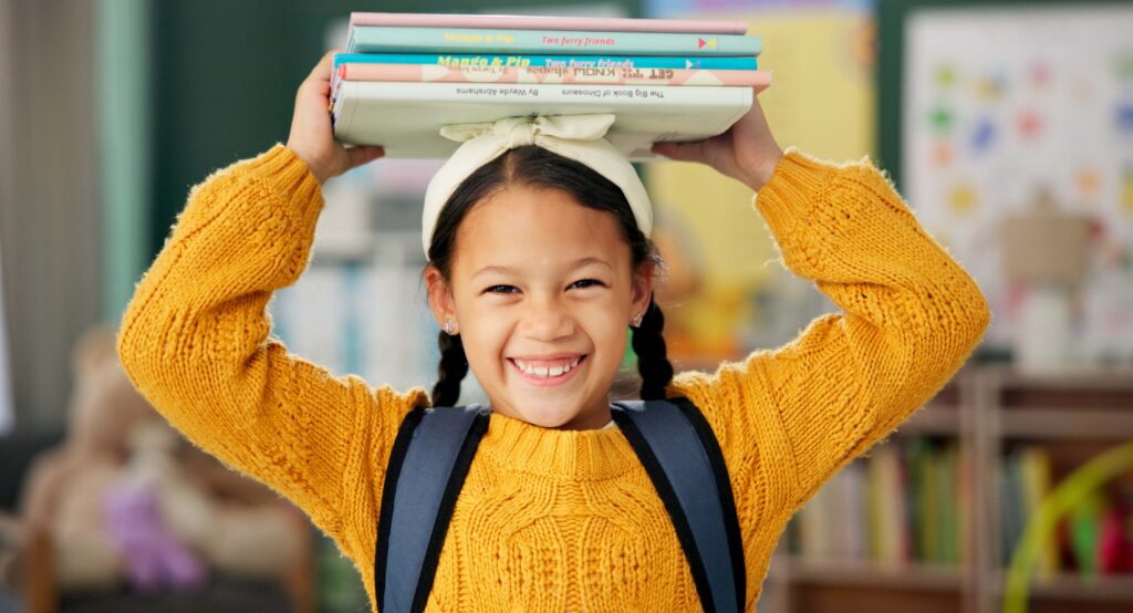girl-books-stacked-on-head-smiling