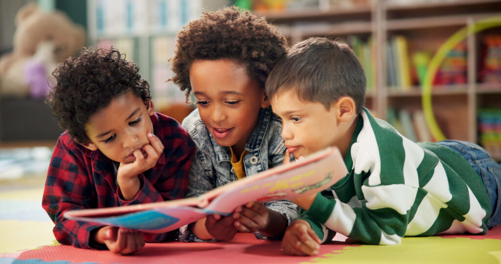 three-students-reading-book-in-classroom-library- area
