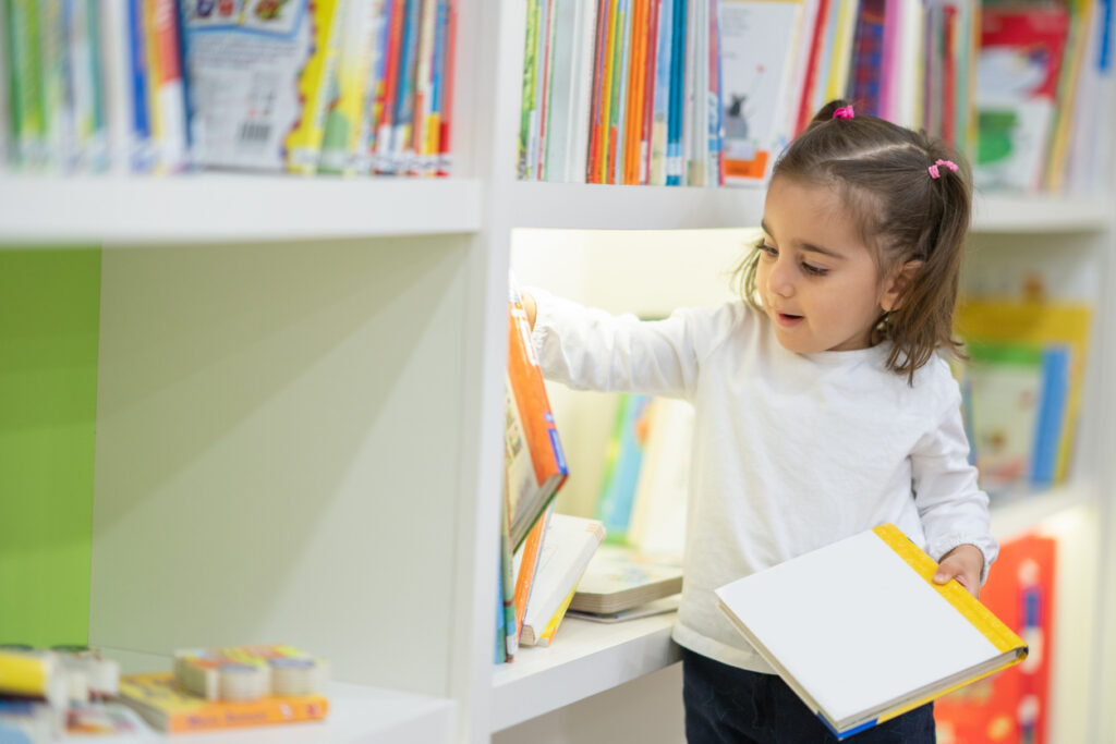 young-student-looking-at-classroom-library-books