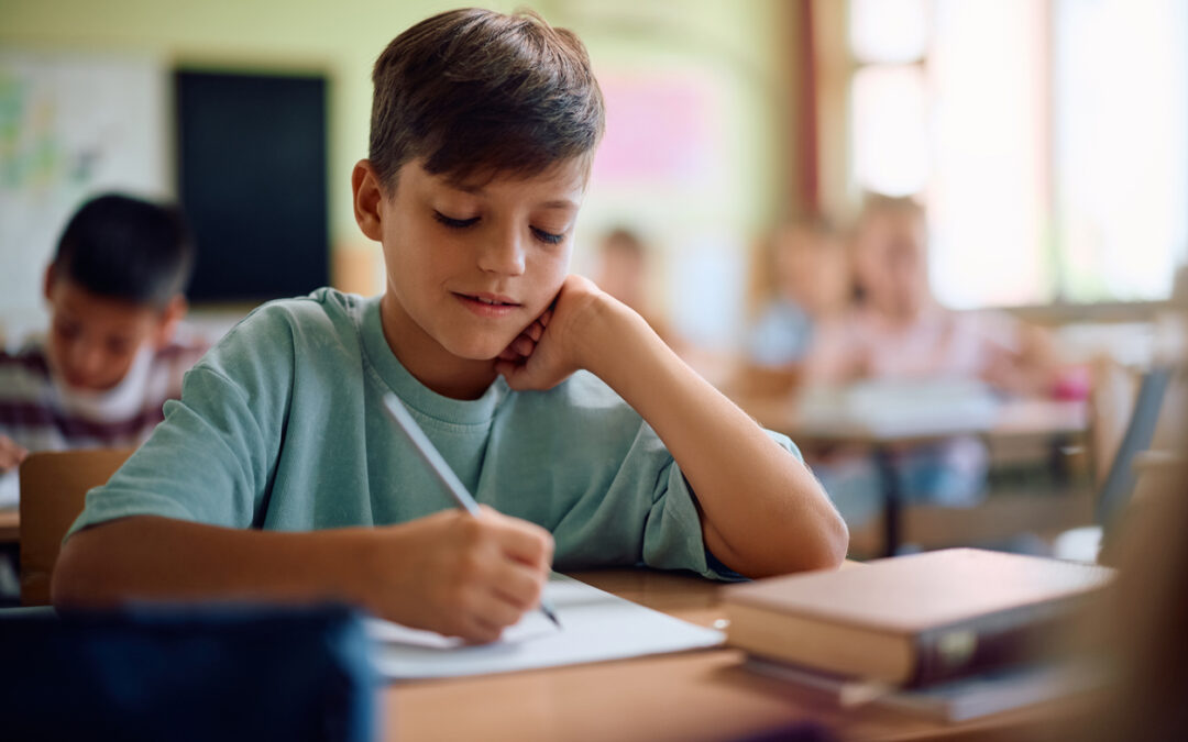 5th-grade-boy-expository-writing-assignment-at-desk
